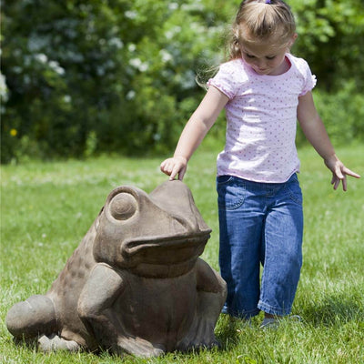 Campania International Giant Garden Frog Statue, set in the garden to add charm and character. The statue is shown in the Pietra Nuova Patina.