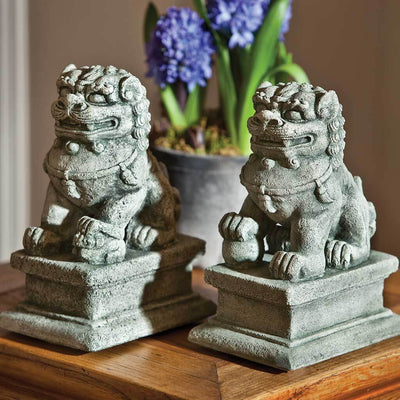 Campania International Small Temple Foo Dog Left and Right Set, set in the garden to adding charm an meaning. The statue is shown in the Alpine Stone Patina.