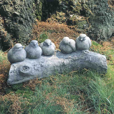 Campania International Birds on a Log Garden Statue , set in the garden to add charm and character. The statue is shown in the Greystone Patina.