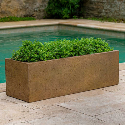 Campania International Rustic Trough Planter filled with evergreens andshown in the Aged Limestone Patina. Made from cast stone.