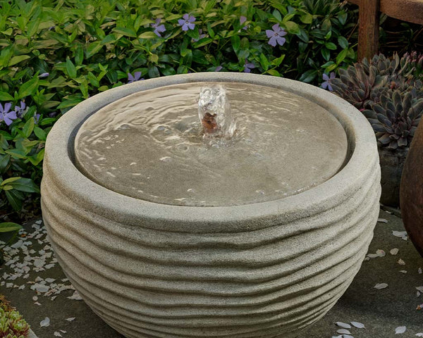 Nami Patio Fountain, a bubbling water feature surrounded by greenery.