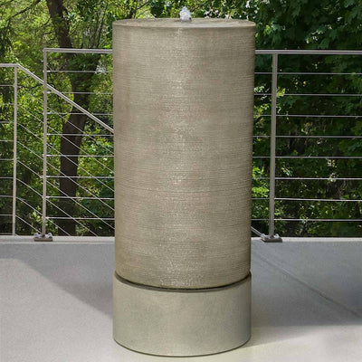 Campania International Tall Cylinder Fountain, shown in hand-painted Verde, a light green-gray patina that works well against multiple colors in the landscape.