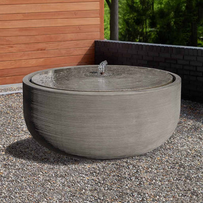 Campania International Girona 6 ft Fountain, shown in hand-painted Alpine Stone, a medium green-gray patina that works well against multiple colors in the landscape.