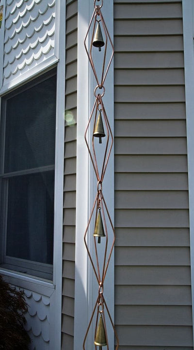 Good Directions Diamond Pure Copper 8.5 ft. Rain Chain with Bells the length of the chain against a home.