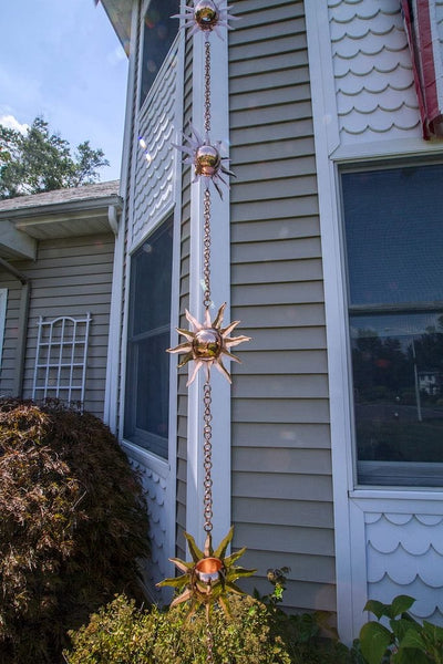 Good Directions Sun Pure Copper 8.5 ft. Rain Chain placed on home in the garden.
