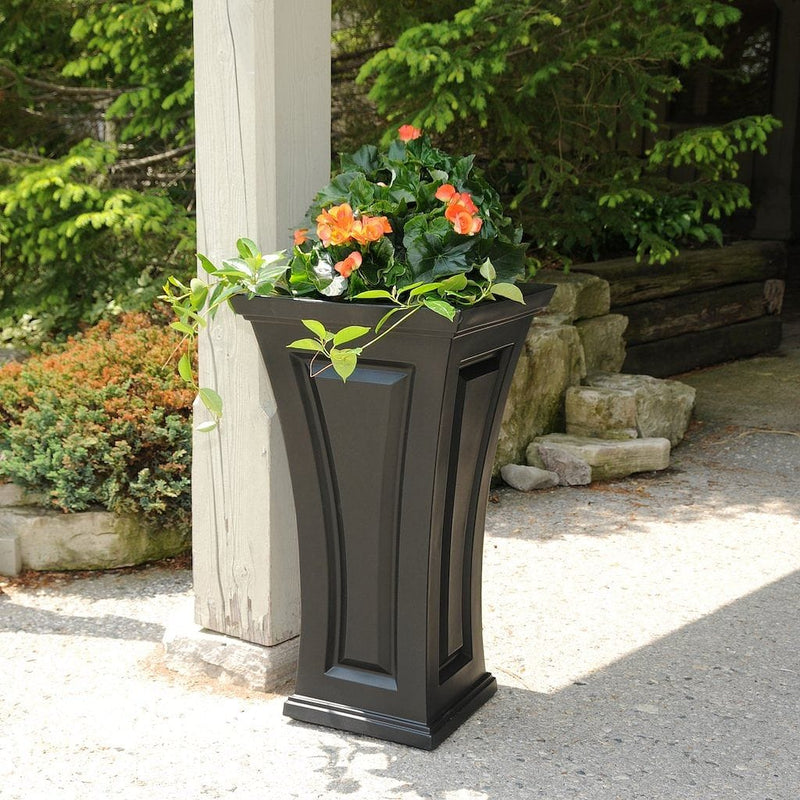 The Mayne Cambridge Tall Planter, in the black finish, planted and placed near home for curb appeal.