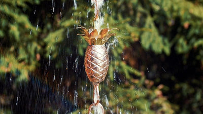 Good Directions Pineapple Pure Copper 8.5 ft. Rain Chain capturing the water in a rain storm.