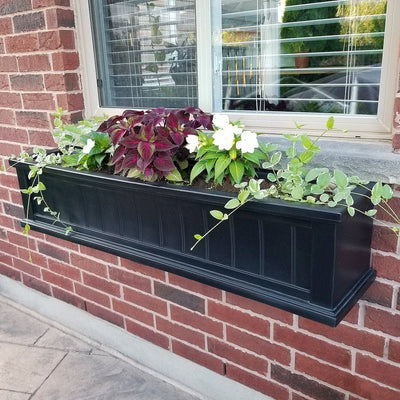 The Mayne Cape Cod 4ft Window Box, in the black finish, planted and mounted on home for curb appeal