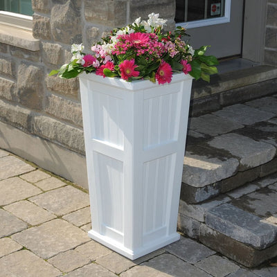 The Mayne Cape Cod Tall Planter, in the white finish, planted and placed near home for curb appeal.