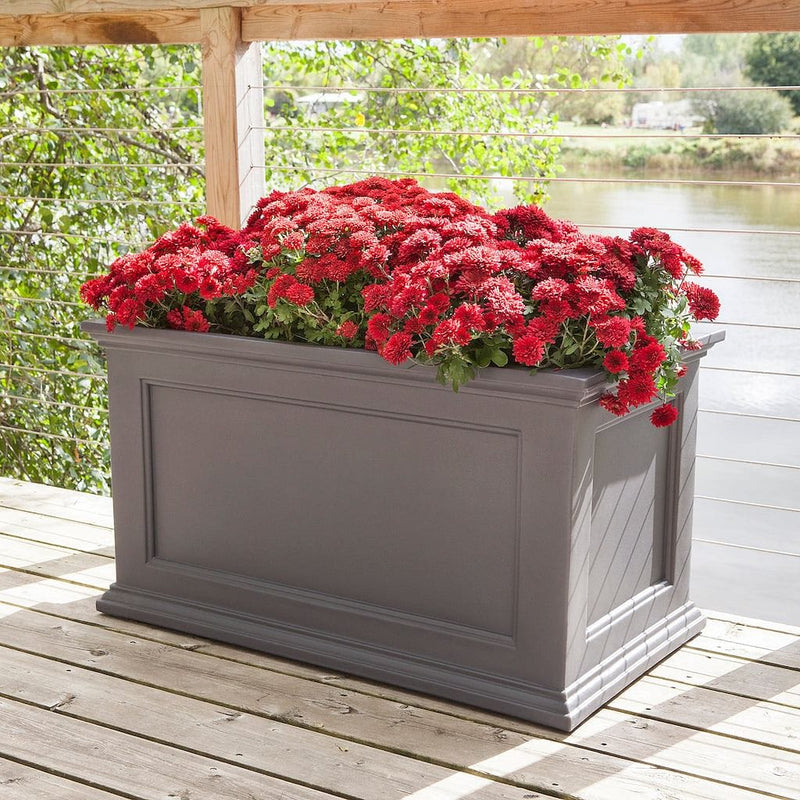 The Mayne Fairfield 20x36 Planter, in the graphite finish,planted and placed near home for curb appeal.