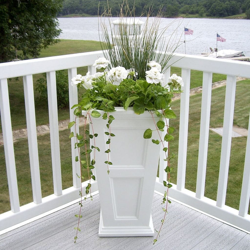 The Mayne Fairfield Tall Planter, in the white finish, planted and placed near home for curb appeal.