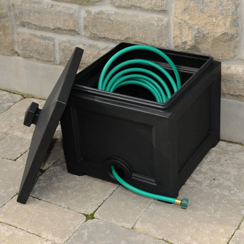 The Mayne Fairfield Garden Hose Bin in Black, in the black finish, storing a hose and ready for use.