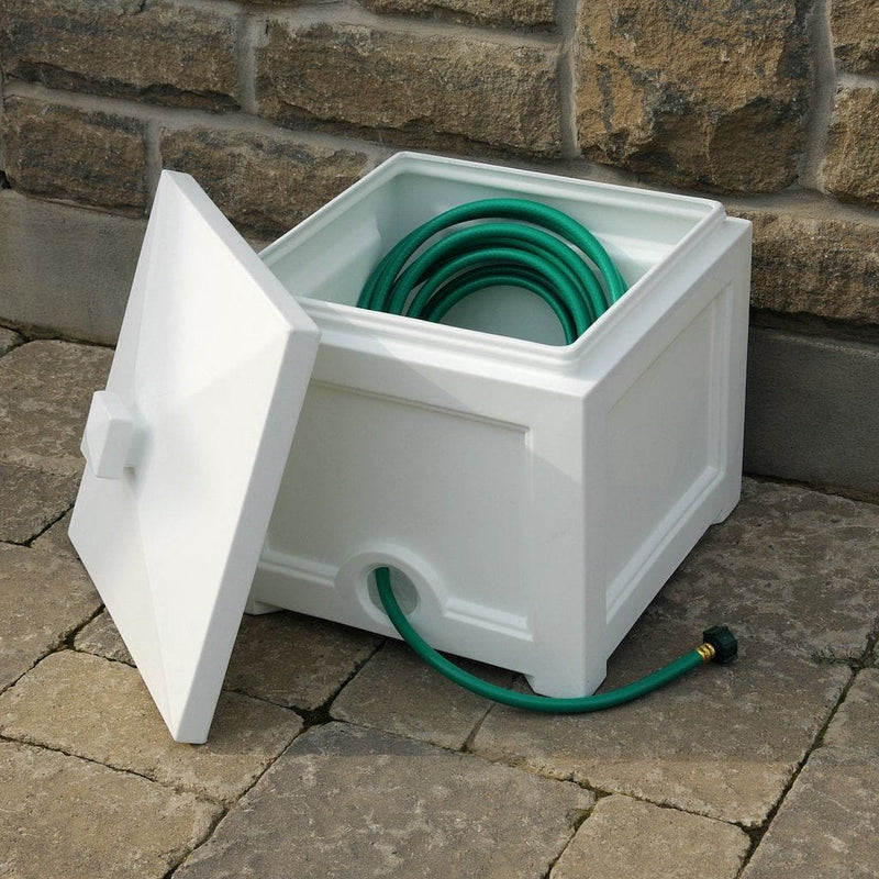 The Mayne Fairfield Garden Hose Bin in White, in the white finish, storing a hose and ready for use.