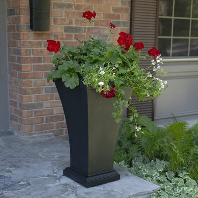 The Mayne Bordeaux Tall Planter, in the black finish, simply planted with flowers to add curb appeal to a front entry of a home.