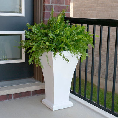 The Mayne Bordeaux Tall Planter, in the white finish, simply planted with soft fern to add curb appeal to a front entry of a home.