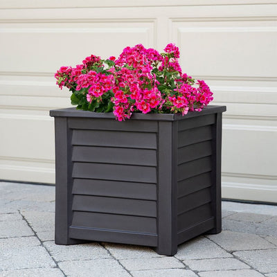 The Mayne Lakeland 20x20 Square Planter, in the espresso finish, planted with cool season annuals, decorating a patio.