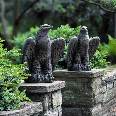Campania International Eagle Looking Left and Right Statue, set in the garden to add charm and character. The statue is shown in the Lead Antique Patina.