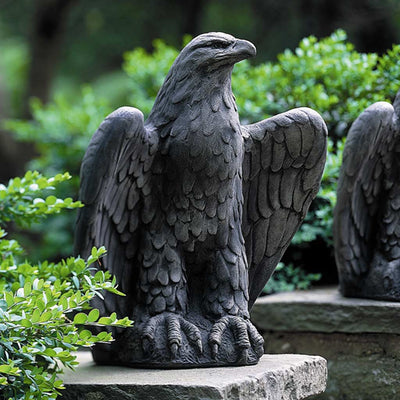 Campania International Eagle Looking Left Statue, set in the garden to add charm and character. The statue is shown in the Alpine Stone Patina.