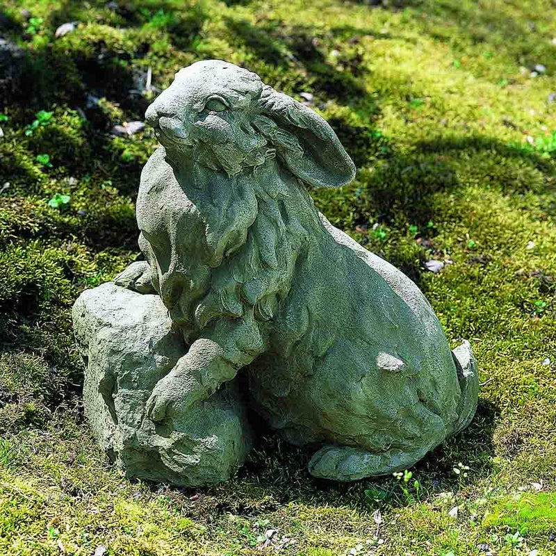 Campania International Rabbit on a Rock Statue, set in the garden to add charm and character. The statue is shown in the Greystone Patina.