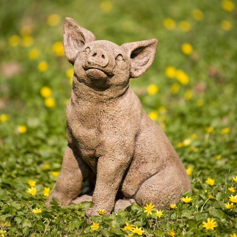 Campania International Perky Pig Statue, set in the garden to add charm and character. The statue is shown in the Brownstone Patina.
