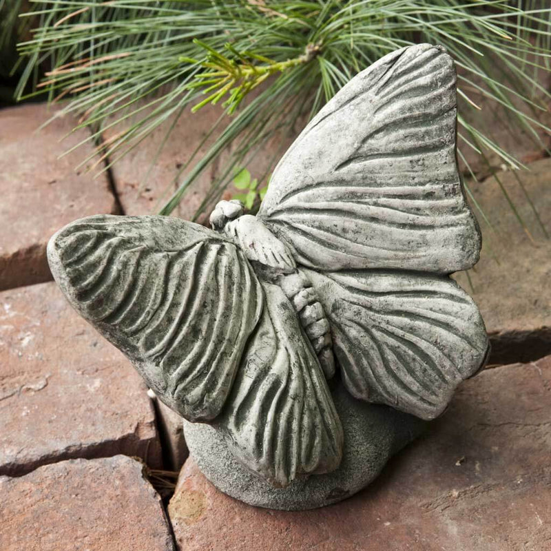 Campania International Butterfly Statue, set in the garden to add charm and character. The statue is shown in the Alpine Stone Patina.
