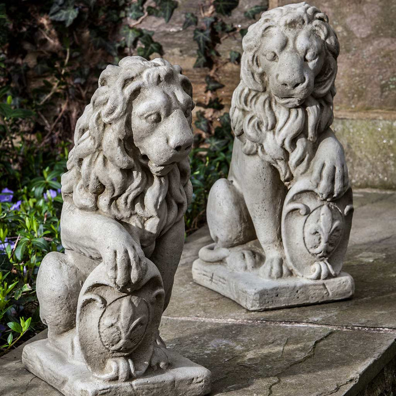 Campania International Small Classic Lion Set Statue, set in the garden to add charm and character. The statue is shown in the Alpine Stone Patina.