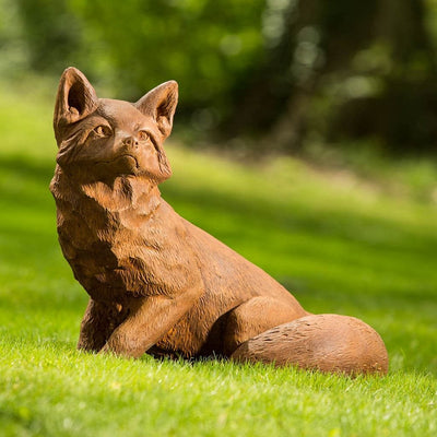 Campania International Noble Fox Statue, set in the garden to add charm and character. The statue is shown in the Ferro Rustico Nuovo Patina.