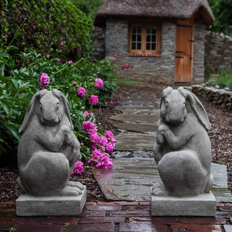 Campania International Newport Rabbit Set Left and Right Statue, set in the garden to add charm and character. The statue is shown in the Greystone Patina.
