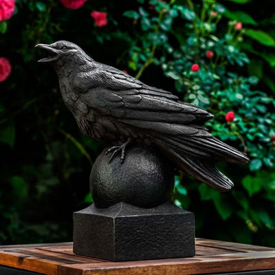 Campania International Corvus Statue, set in the garden to add charm and character. The statue is shown in the Nero Nuovo Patina.