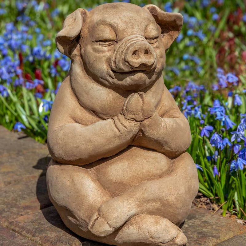 Campania International Zen Pig Statue, set in the garden to add charm and character. The statue is shown in the Brownstone Patina.