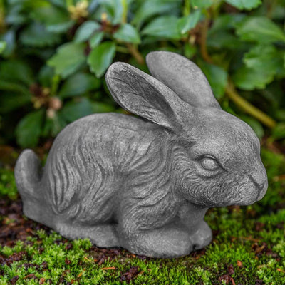 Campania International Bunny Statue, set in the garden to add charm and character. The statue is shown in the Greystone Patina.
