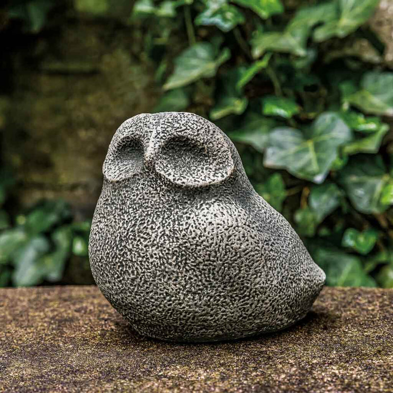 Campania International Stone Owl Statue, set in the garden to add charm and character. The statue is shown in the Greystone Patina.