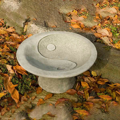 Campania International Yin Yang Pedestal Birdbath, shown in hand-painted Verde, a light green-gray patina that works well against multiple colors in the landscape.