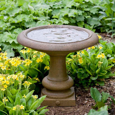Campania International Williamsburg Summer House, set in the garden to adding charm and purpose. The birdbath is shown in the Aged Limestone Patina.