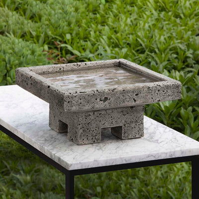 Campania International Kosei Birdbath, shown in the Alpine Stone color, highlighting and enriching the details of the cast stone.