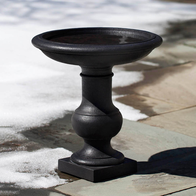 Campania International Balustrade Birdbath, set in the garden to adding charm and purpose. The birdbath is shown in the Nero Nuovo Patina.