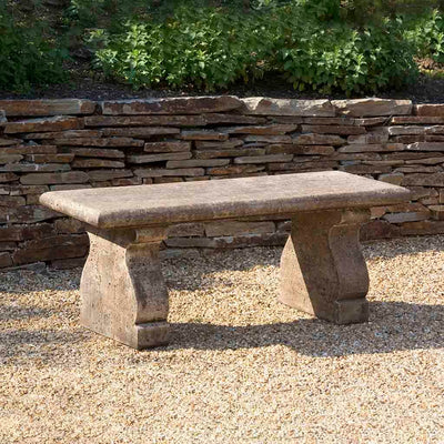 Campania International Provencal Bench, set in the garden to adding charm and purpose. The bench is shown in the Brownstone Patina.