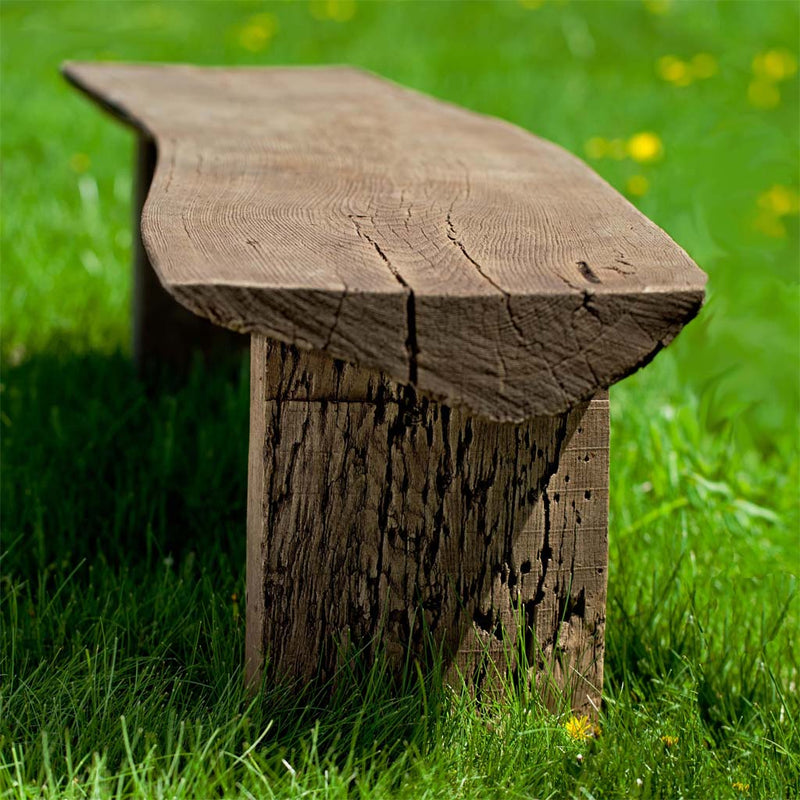 Campania International Small Bois Garden Bench, set in the garden to adding charm and purpose. The bench is shown in the Brownstone Patina.