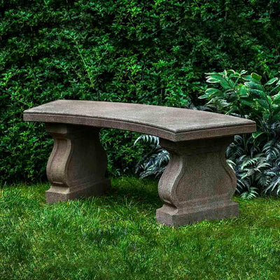 Campania International Arles Bench, set in the garden to adding charm and purpose. The bench is shown in the Aged Limestone Patina.