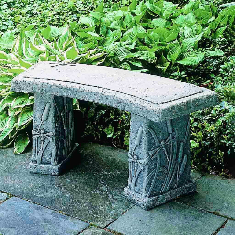 Campania International Dragonfly Curved Bench, set in the garden to adding charm and purpose. The bench is shown in the Alpine Stone Patina.