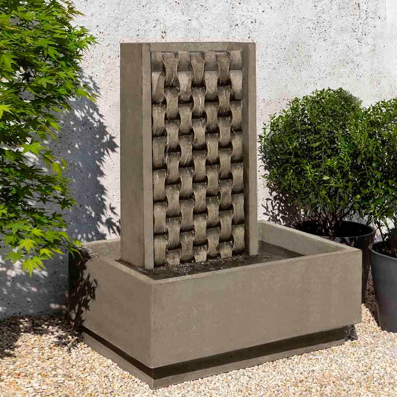 Campania International M Weave Fountain, adding interest to the garden with the sound of water. This fountain is shown in the Alpine Stone Patina.