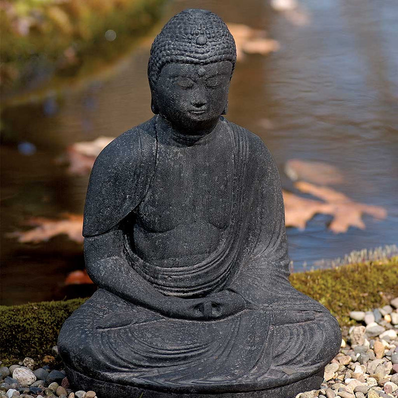 Campania International Buddha Statue, set in the garden to adding charm an meaning. The statue is shown in the Nero Nuovo Patina.