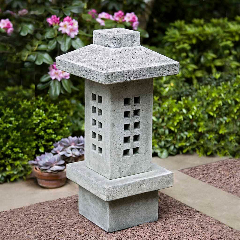 Campania International Naka Lantern, set in the garden to adding charm an meaning. The statue is shown in the Alpine Stone Patina.