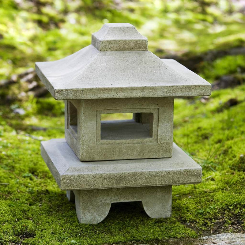 Campania International Atsumi Lantern, set in the garden to adding charm an meaning. The statue is shown in the Verde Patina.
