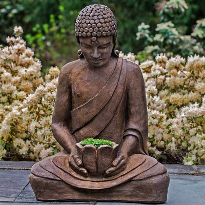 Campania International Lotus Buddha Statue, set in the garden to adding charm an meaning. The statue is shown in the Pietra Nuova Patina.