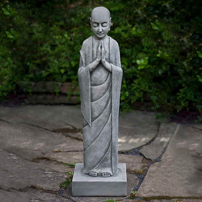 Campania International Venerable Monk Statue, set in the garden to adding charm an meaning. The statue is shown in the Alpine Stone Patina.