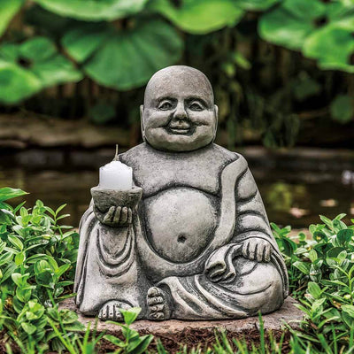 Campania International Small Abaca Buddha Statue, set in the garden to adding charm an meaning. The statue is shown in the Greystone Patina.
