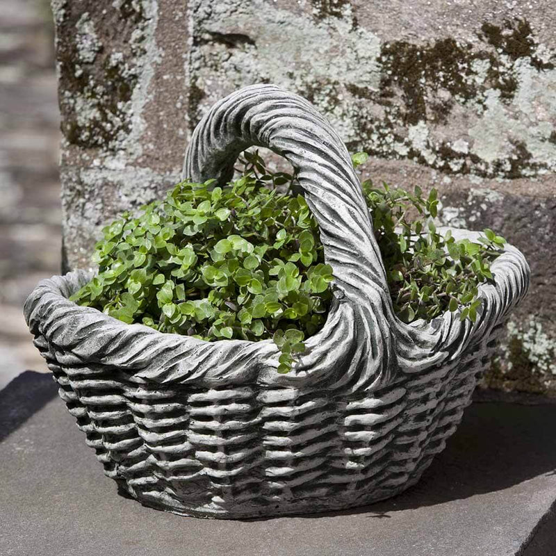 Campania International Basket with Handle Small Planter is shown in the Alpine Stone Patina. Made from cast stone.