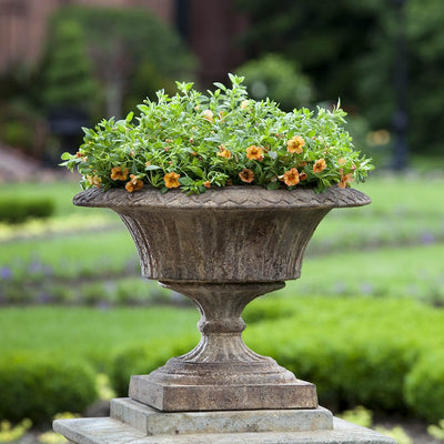 Campania International Smithsonian Fluted Valentine Urn is shown in the Pietra Nuovo Patina. Made from cast stone.