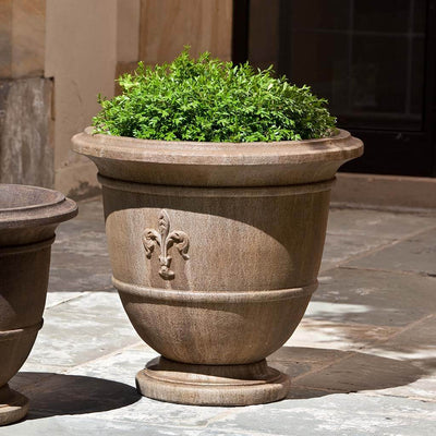 Campania International Fleur de Lis Large Urn is shown in the Age Limestone Patina. Made from cast stone.
